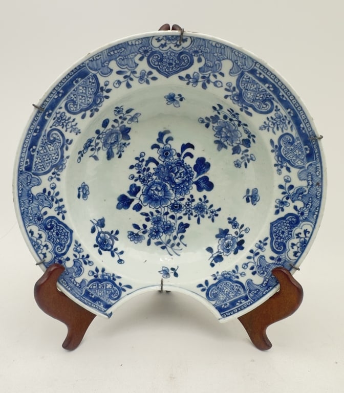 A finely painted Chinese export porcelain charger decorated in underglaze cobalt blue. The center: A finely painted Chinese export porcelain charger decorated in underglaze cobalt blue. The center features a naturalistic floral bouquet surrounded by scattered sprigs, enclosed within a broad cavetto