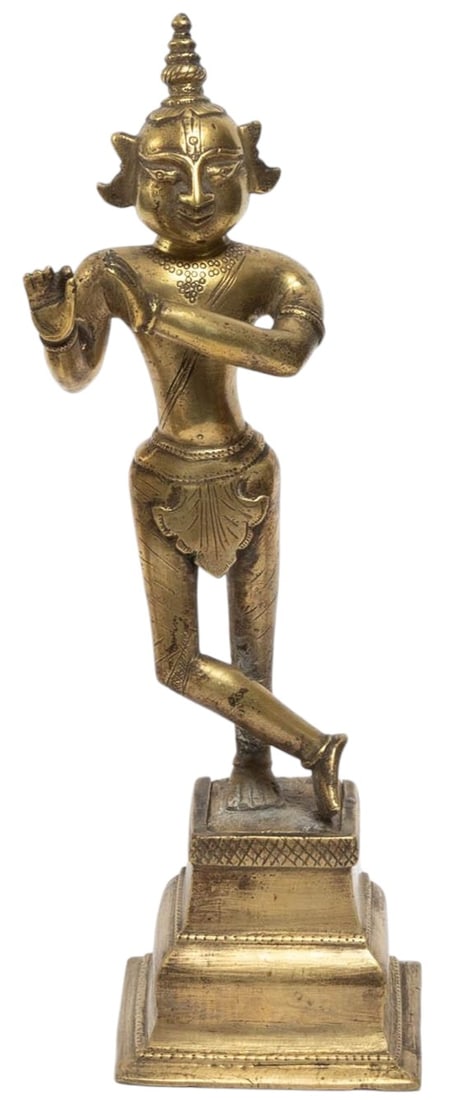 An Indian brass figure depicting Krishna in a dancing pose, shown standing with one leg crossed (1 of 3)