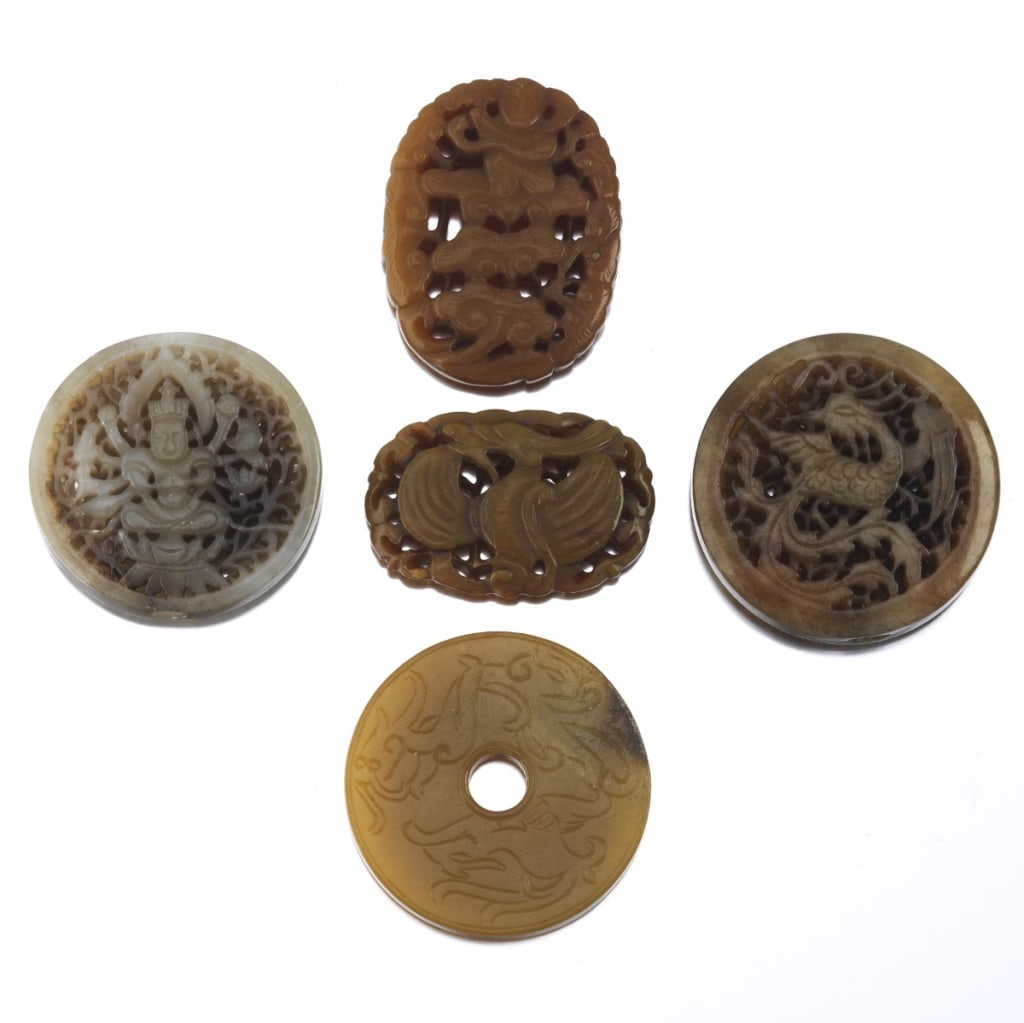 A group of five finely carved Chinese jade and hardstone pendants, each rendered in varying tones (1 of 6)