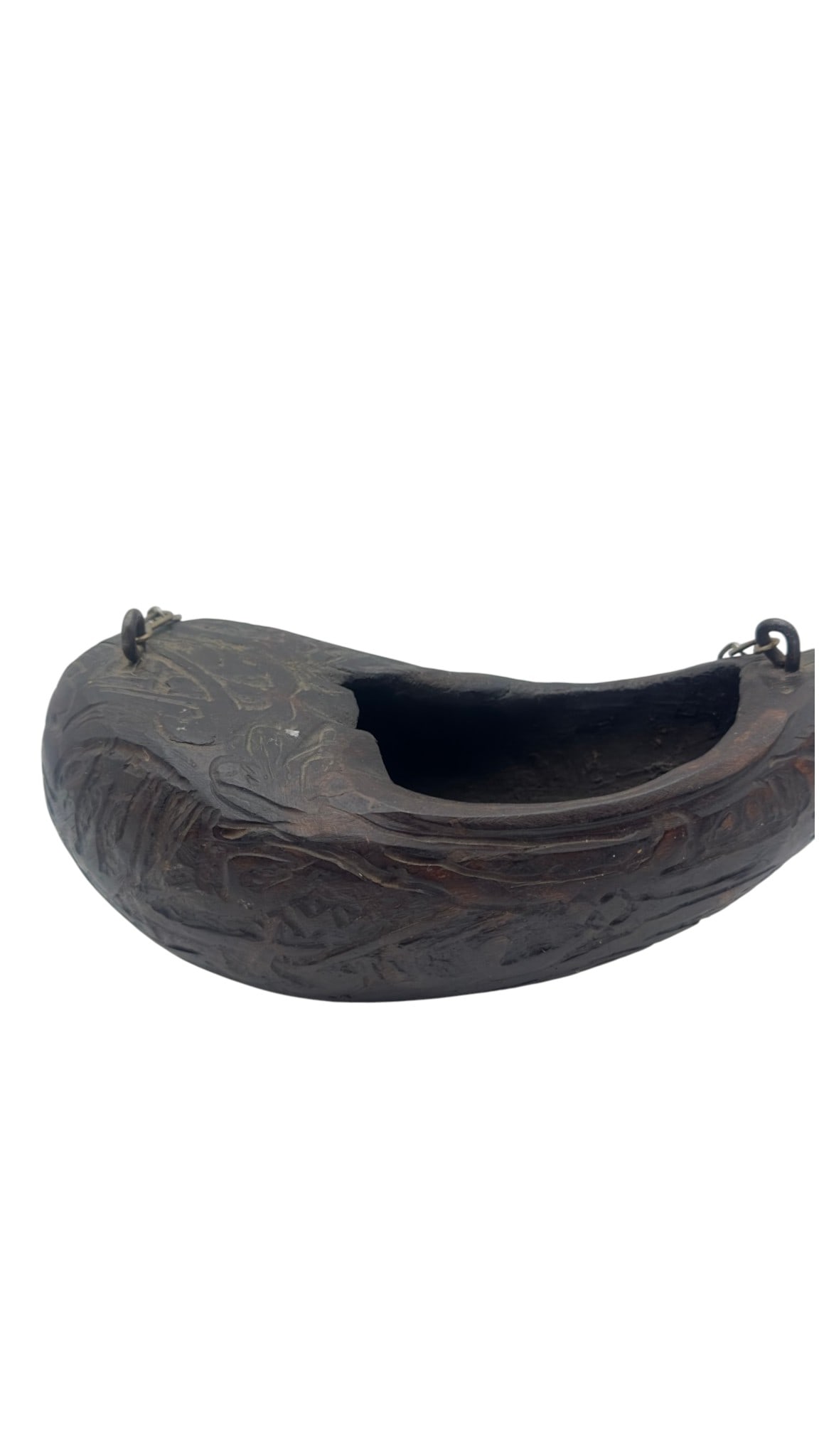 A carved kashkul of traditional crescent form, likely fashioned from horn or similar organic: A carved kashkul of traditional crescent form, likely fashioned from horn or similar organic material, decorated in relief with figural and animal motifs. The surface displays a rich dark patina with 