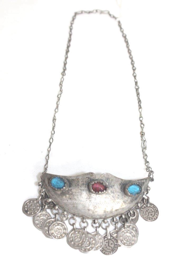 Tibetan silver necklace with teal and ruby glass gems, carefully hand cut coin sheet: Tibetan silver necklace with teal and ruby glass gems, carefully hand cut coin sheet embellishments pieced together providing form to the necklace. L 9.5 ins (24.2 cms);