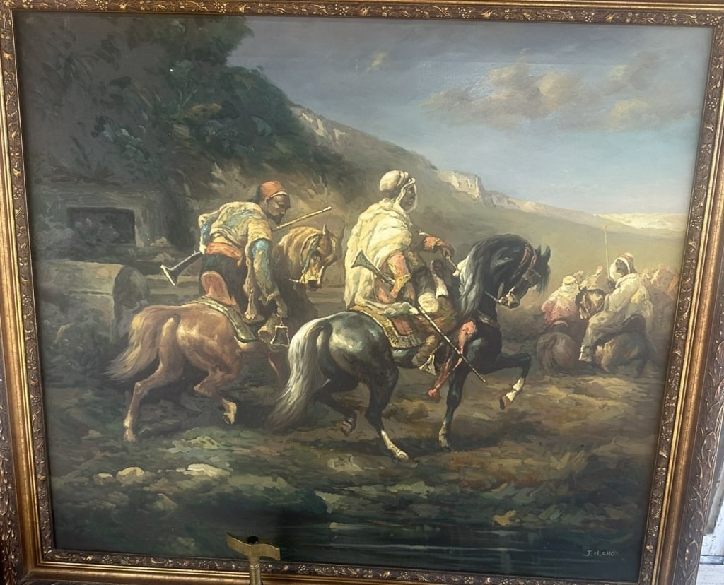 Oil painting depicting an Orientalist equestrian scene with mounted figures traversing a: Oil painting depicting an Orientalist equestrian scene with mounted figures traversing a mountainous landscape. The composition centered by riders on horseback surrounded by additional figures in