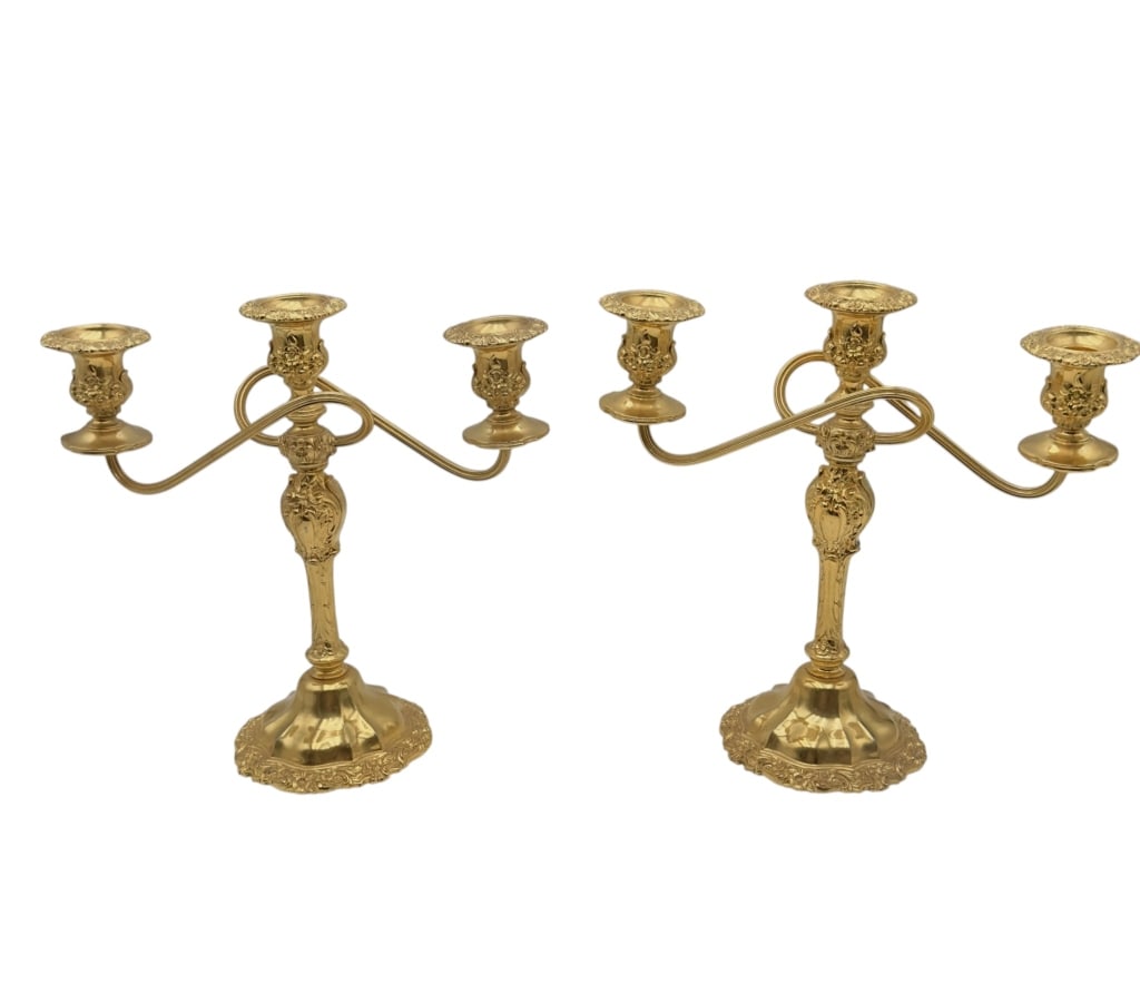 An elegant pair of American three -light candelabra by the International Silver Company, featuring: An elegant pair of American three -light candelabra by the International Silver Company, featuring a refined neoclassical design with scrolling arms and a central baluster-form stem. Each example is f