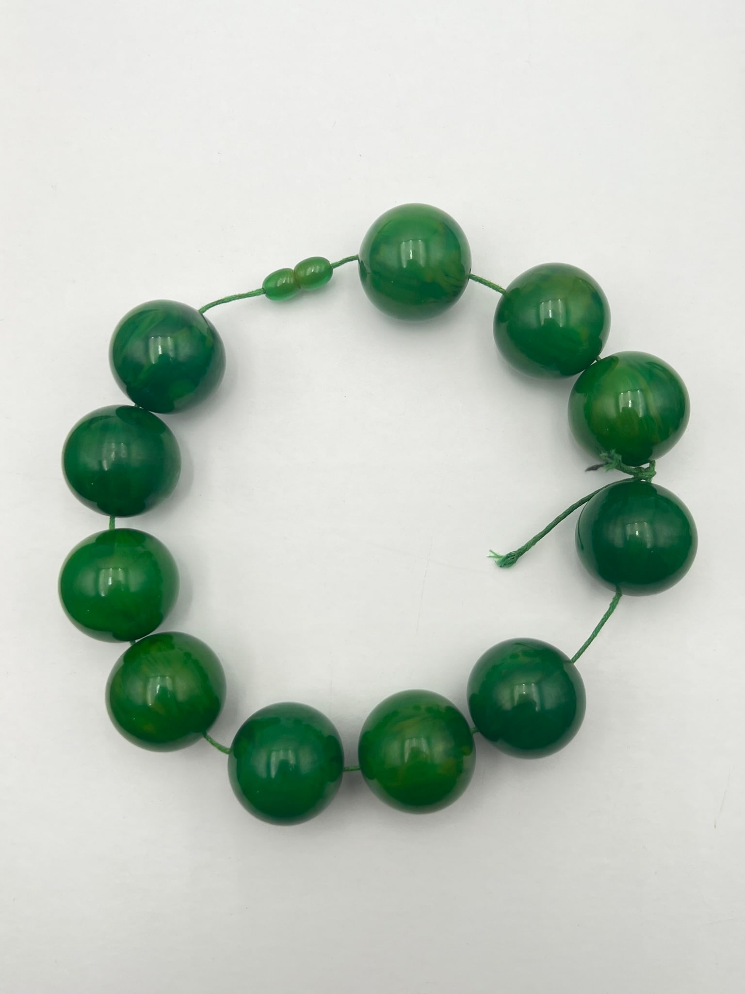 Vintage Bakelite Green Marbled Bead Strand / Prayer Beads: Vintage Bakelite bead strand composed of large graduated spherical beads in rich green tones with attractive marbled swirls and polished finish. The beads display varied translucency and swirling colo