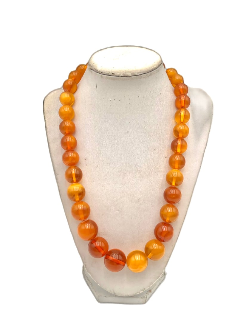 Vintage Butterscotch Amber Graduated Bead Necklace: Vintage necklace composed of graduated butterscotch amber-tone beads in warm honey and caramel hues, displaying subtle marbling and a polished finish. The beads vary in size, increasing toward the cen
