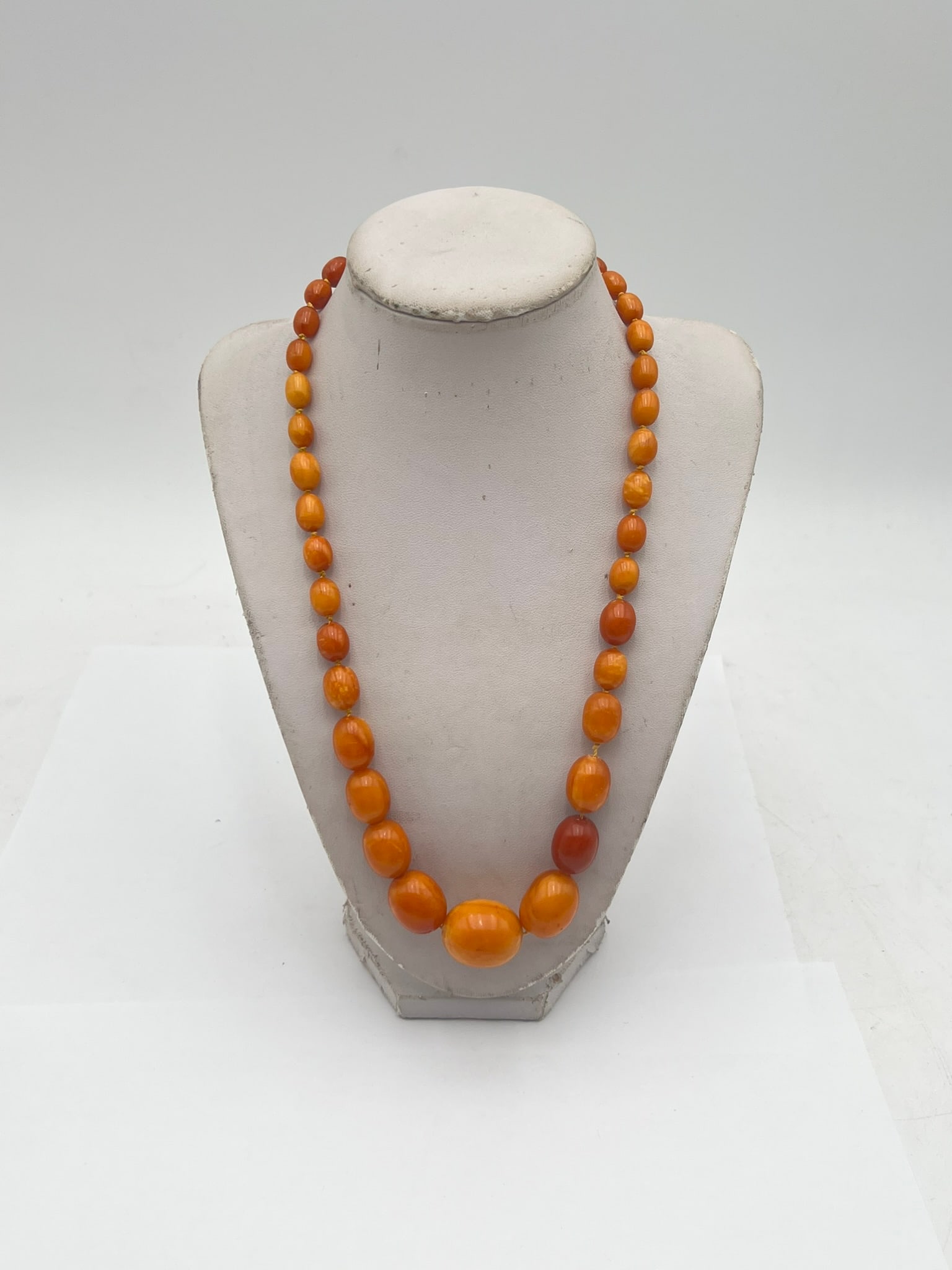 Vintage Butterscotch Amber Graduated Bead Necklace: Vintage necklace composed of graduated butterscotch amber-tone beads in warm honey and caramel hues, displaying subtle marbling and a polished finish. The beads vary in size, increasing toward the cen