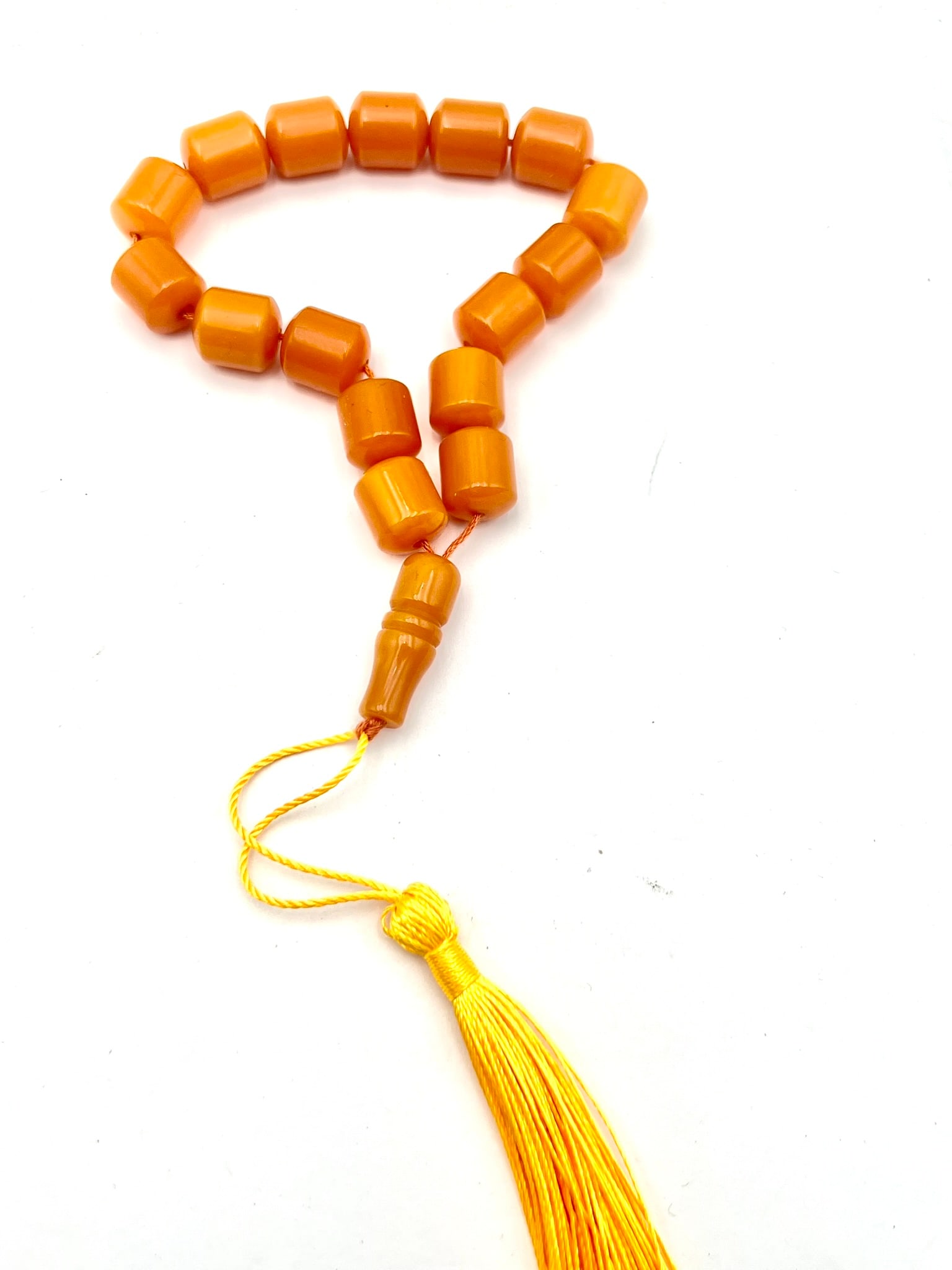 Bakelite Style Prayer Beads (Misbaha / Tasbih), Amber Color: A vintage-style strand of prayer beads featuring cylindrical amber-tone beads with a polished finish and warm translucent orange hue. Completed with a matching separator and decorative tassel. A class