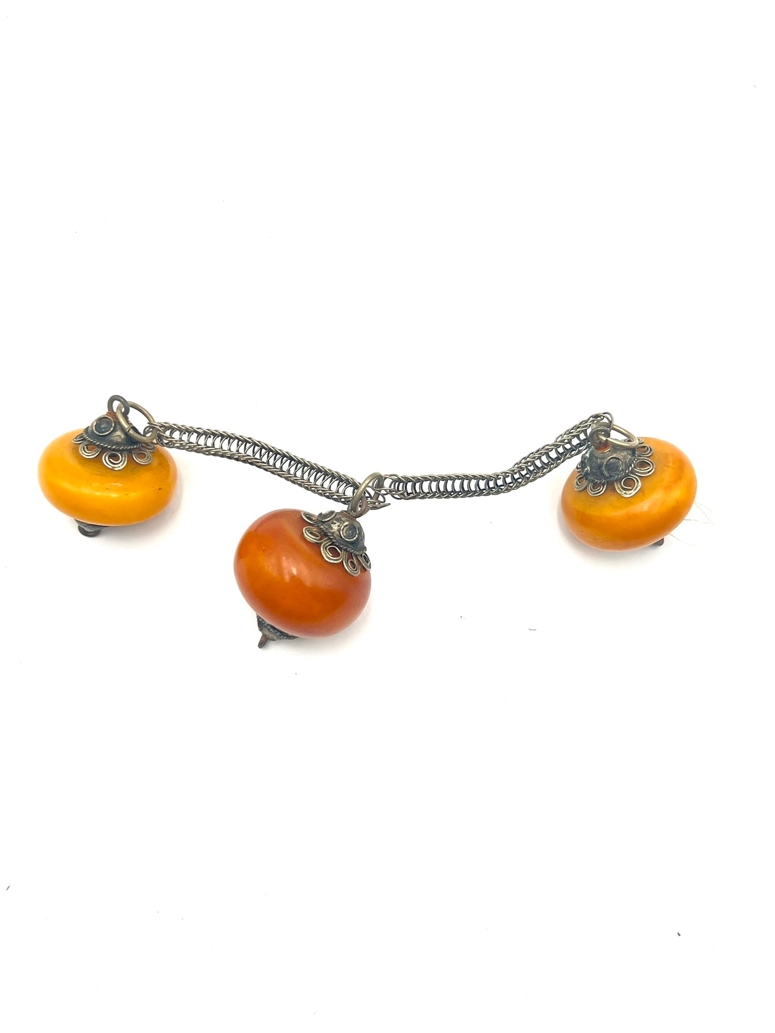Vintage Bakelite Style Charm Brooch / Pin: A decorative vintage-style brooch featuring three suspended butterscotch and amber-tone Bakelite-style beads with warm marbled coloration. Mounted with ornate silver-tone caps and linked by twisted me