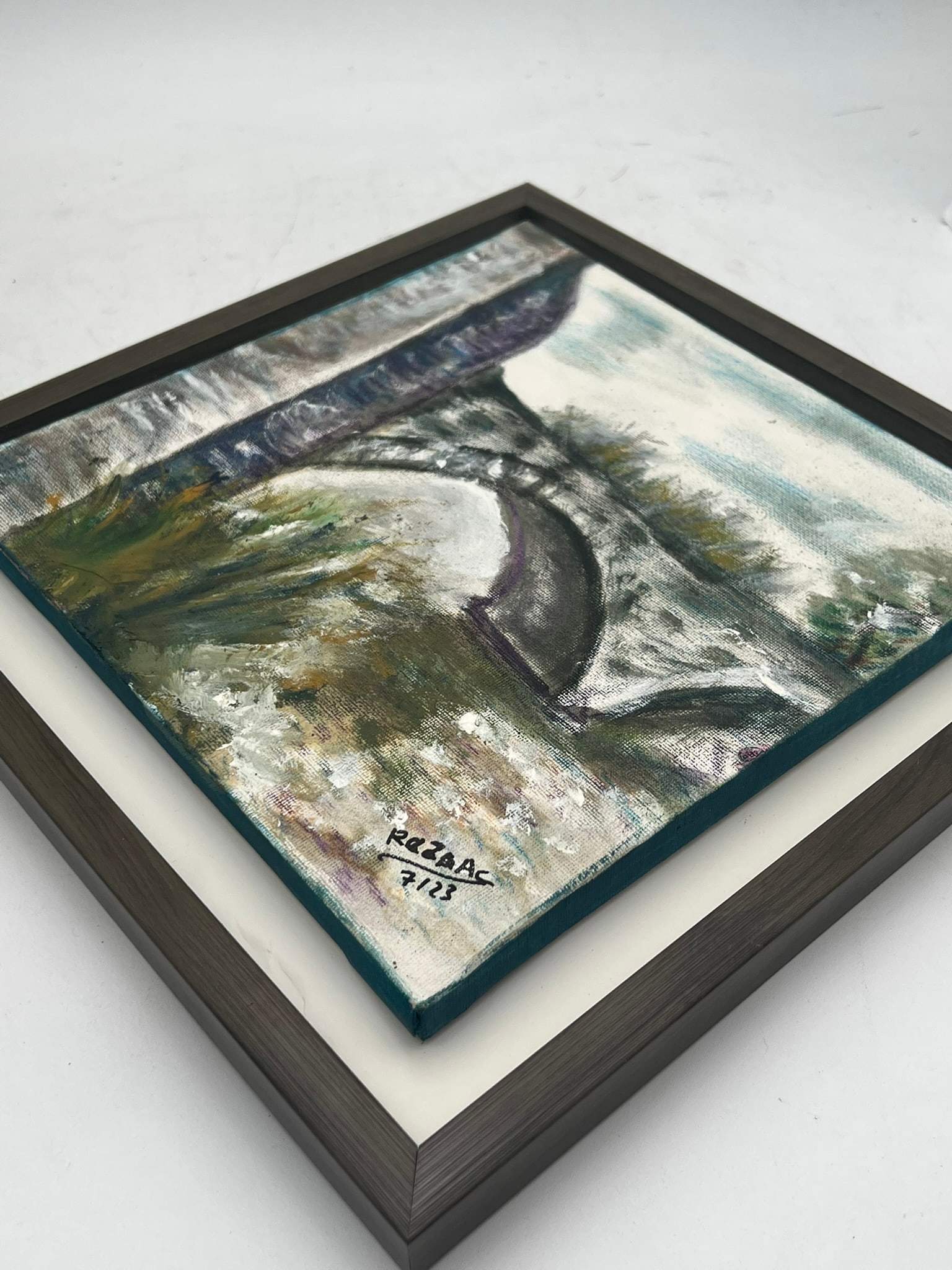 Signed Oil on Canvas, Bridge Landscape: A signed oil on canvas depicting an impressionistic landscape scene centered on a stone arched bridge over flowing water. Executed in expressive brushwork with muted tones of gray, green, blue, and ea