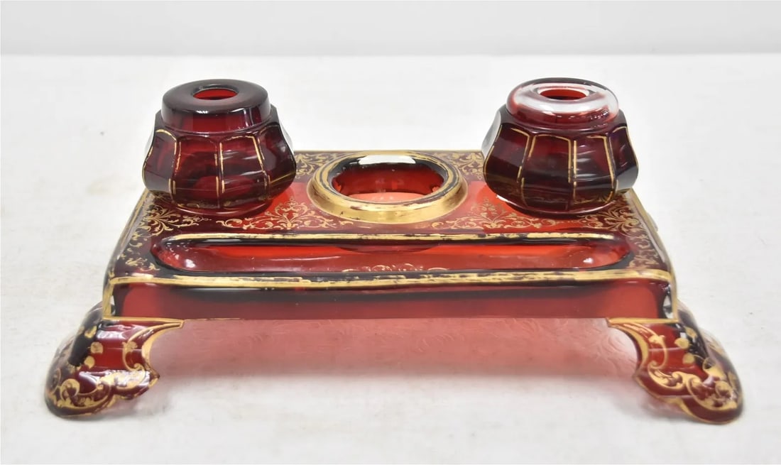 REAR 19 CENTURY BOHEMIAN GLASS DOUBLE INKWELL An elegant 19th century Bohemian ruby red glass: An elegant 19th century Bohemian ruby red glass double inkwell stand, richly decorated with hand-applied gilding. The rectangular base is supported by shaped feet and features intricate foliate scroll