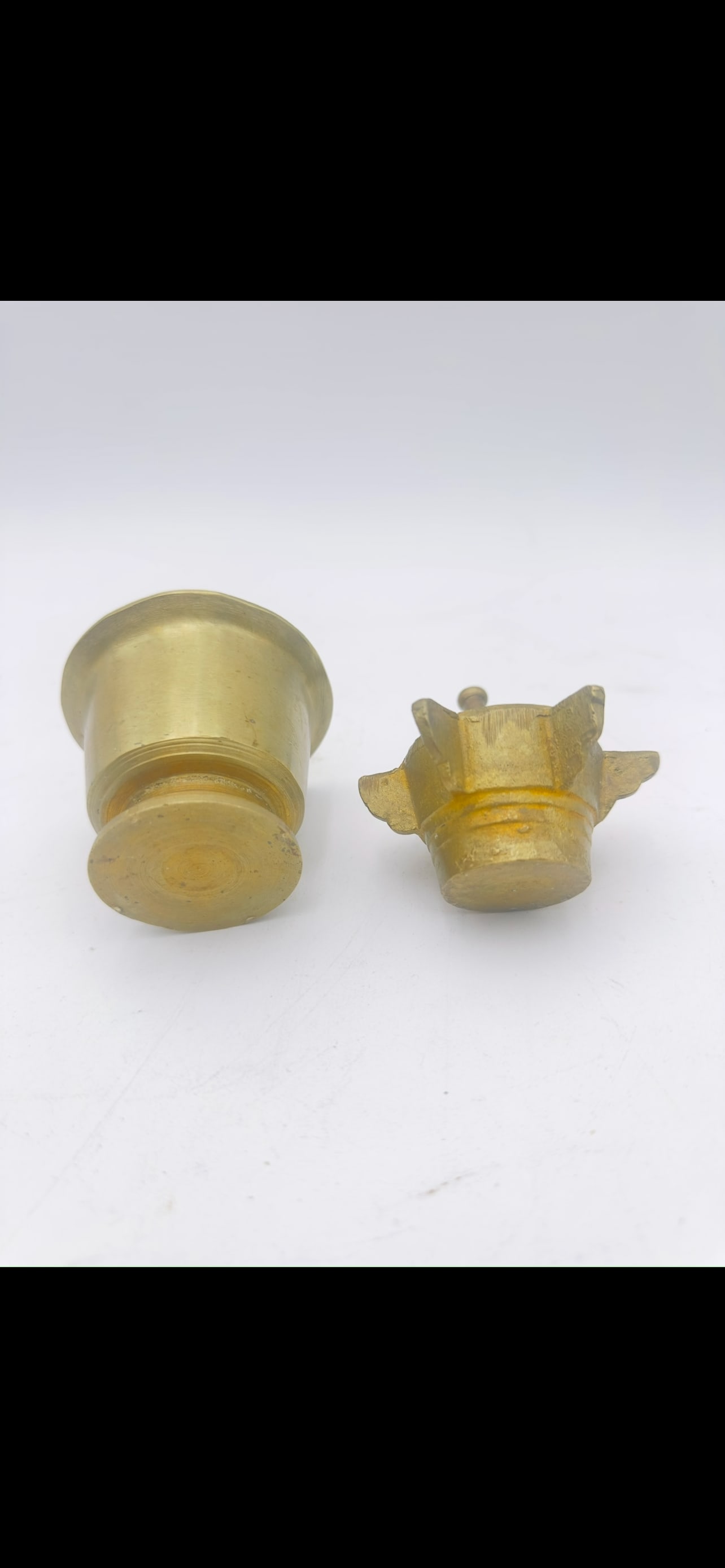 Two Brass Mortars and Pestles, Middle Eastern and European Style, 19th: A lot of two solid brass mortars, each accompanied by its original pestle. The group includes a large, plain tapered mortar with a turned brass pestle, and a smaller mortar with four projecting lugs (