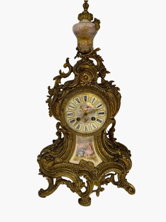 A FRENCH ROCOCO REVIVAL GILT-BRONZE AND PORCELAINY An ornate French Rococo Revival mantel clock,: An ornate French Rococo Revival mantel clock, circa late 19th century, the richly cast gilt-bronze case decorated with elaborate scrolling acanthus, foliate and shell motifs. The porcelain dial with i