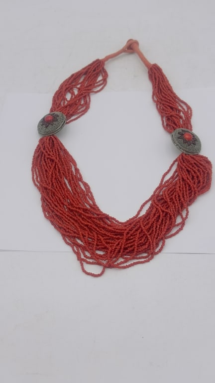 Multi-Strand Coral Bead Necklace Decorative multi-strand coral bead necklace composed of numerous: Decorative multi-strand coral bead necklace composed of numerous strands of vivid red coral-colored beads gathered at silver-tone floral form spacers accented with cabochon coral-colored centers. The 