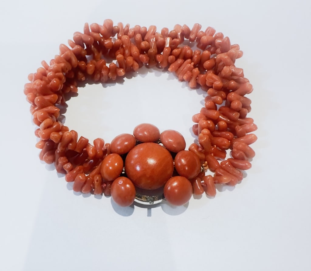 Vintage Mediterranean Coral Multi-Strand Bracelet A vintage bracelet composed of multiple strands of: A vintage bracelet composed of multiple strands of natural salmon coral branch beads, terminating in a decorative cluster clasp set with polished coral beads. The bracelet displays the soft coloration