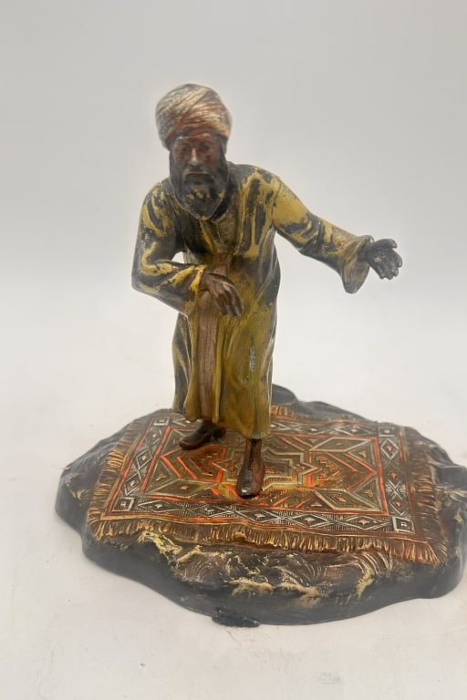 Orientalist Cold-Painted Bronze Figure on Carpet e Orientalist Cold-Painted Bronze Figure on Carpet: Orientalist Cold-Painted Bronze Figure on Carpet Base, Early 20th CenturyA finely modeled cold-painted bronze figure depicting a Middle Eastern man wearing a turban and traditional robe, extending his