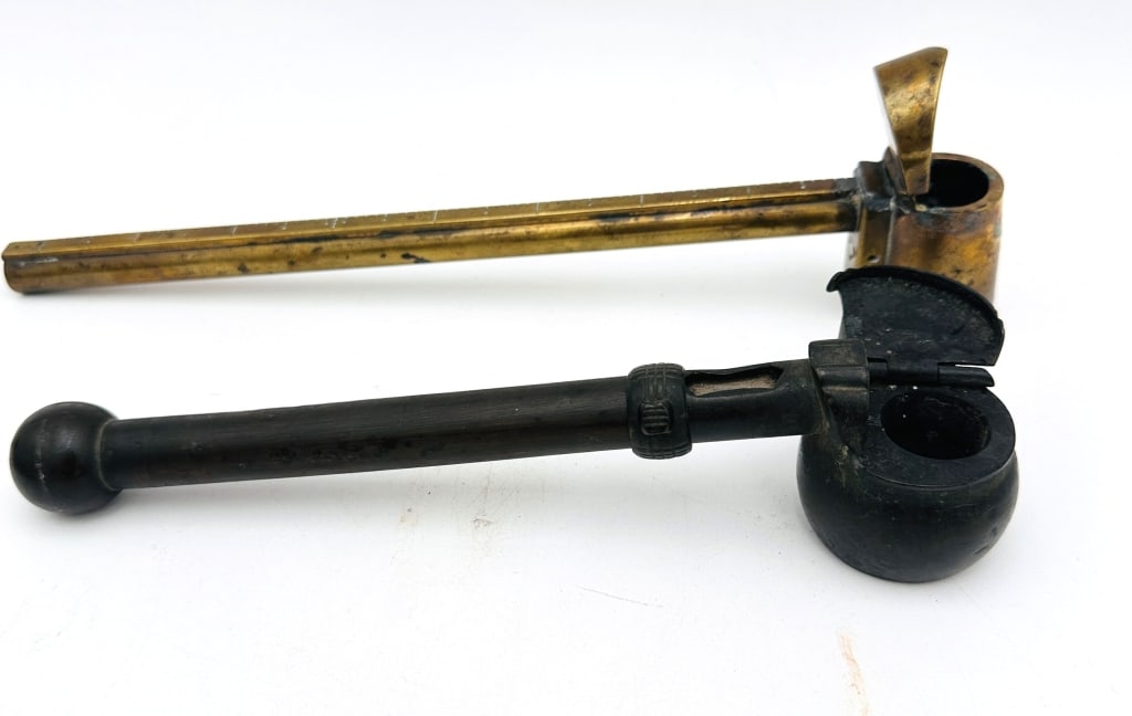 Two Japanese Yatate, Edo?Meiji Period (19th Centur A pair of traditional portable Japanese writing: A pair of traditional portable Japanese writing sets (yatate), each with tubular shaft for brush storage attached to an ink reservoir with hinged lid. One example in brass with a long, slender form; t