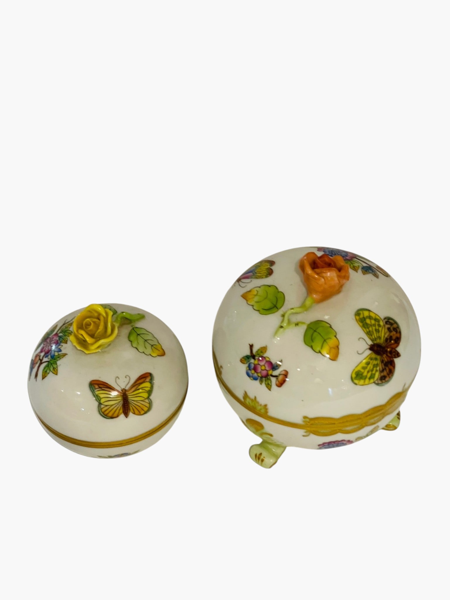 TWO HEREND QUEEN VICTORIA PORCELAIN COVERED SUGARS Two Herend hand-painted porcelain covered sugar: Two Herend hand-painted porcelain covered sugar bowls in the celebrated Queen Victoria (VBO) pattern, decorated with colorful butterflies, floral sprays and foliage with gilt highlights. Each domed co