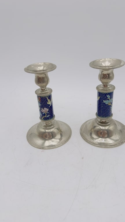 Pair of Silver Plate & Cloisonn? Enamel Candlestis A decorative pair of silver-plated candlesticks: A decorative pair of silver-plated candlesticks featuring cylindrical stems adorned with vibrant blue cloisonn? enamel decorated with flying cranes, lotus blossoms, and cloud motifs. The polished silv