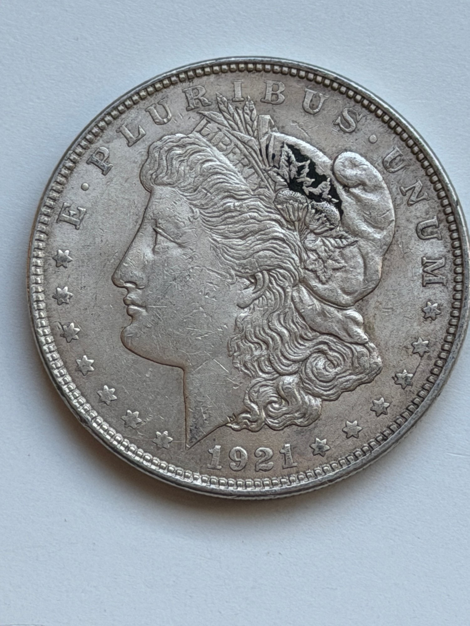 1921 Morgan Silver Dollar: This 1921 Morgan Silver Dollar marks the final year of production for this legendary American coin series. Struck in 90% silver, the coin features George T. Morgan’s iconic profile of Lady Liberty o