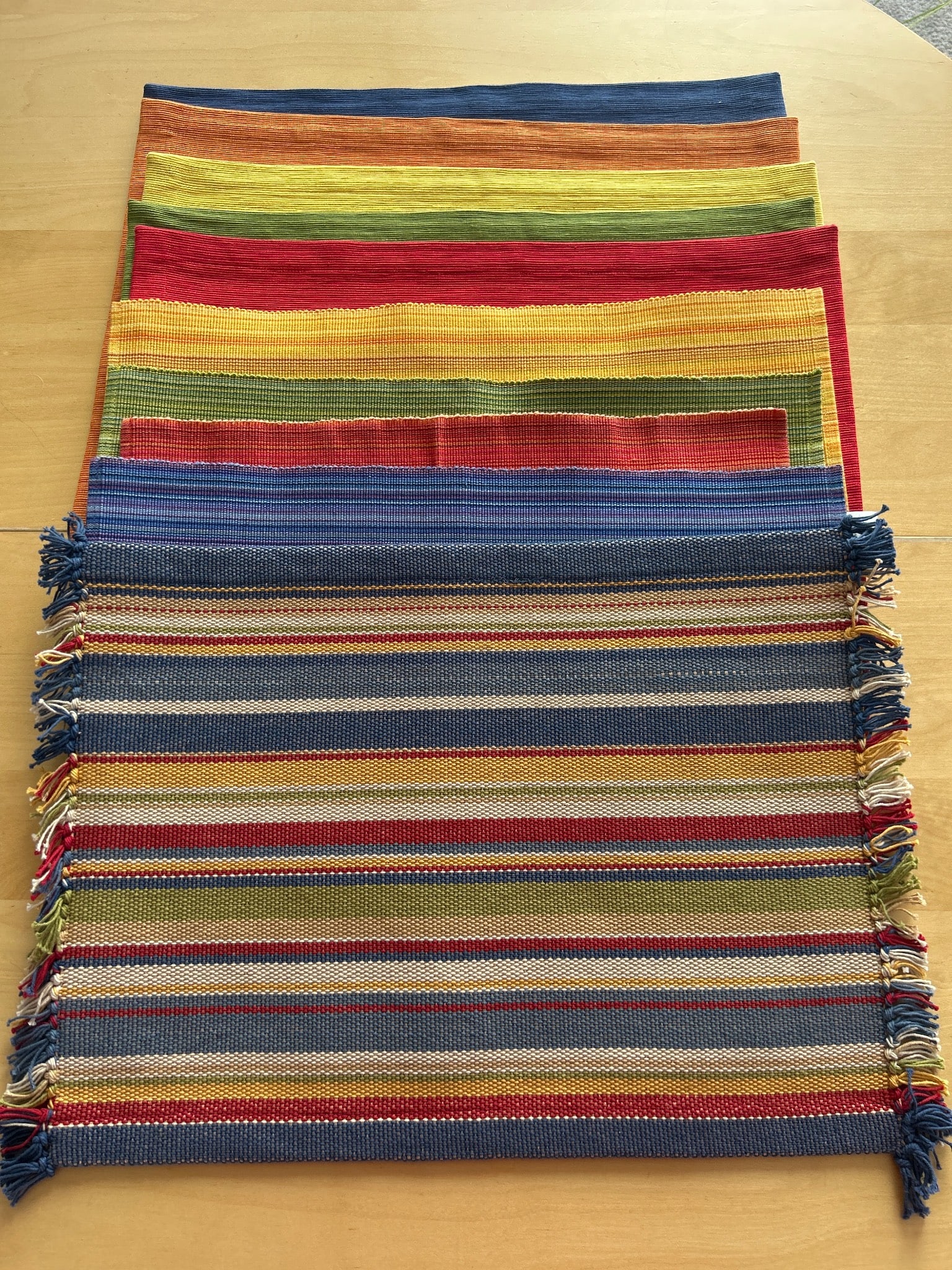 Crate & Barrel Wyatt Placemats, Multicolor Stripes: Crate & Barrel Wyatt placemats featuring a multicolor striped design with fringe trim. Made in India from woven fabric, these placemats are labeled as 14 inches by 19 inches (35.5 cm x 48 cm). Include