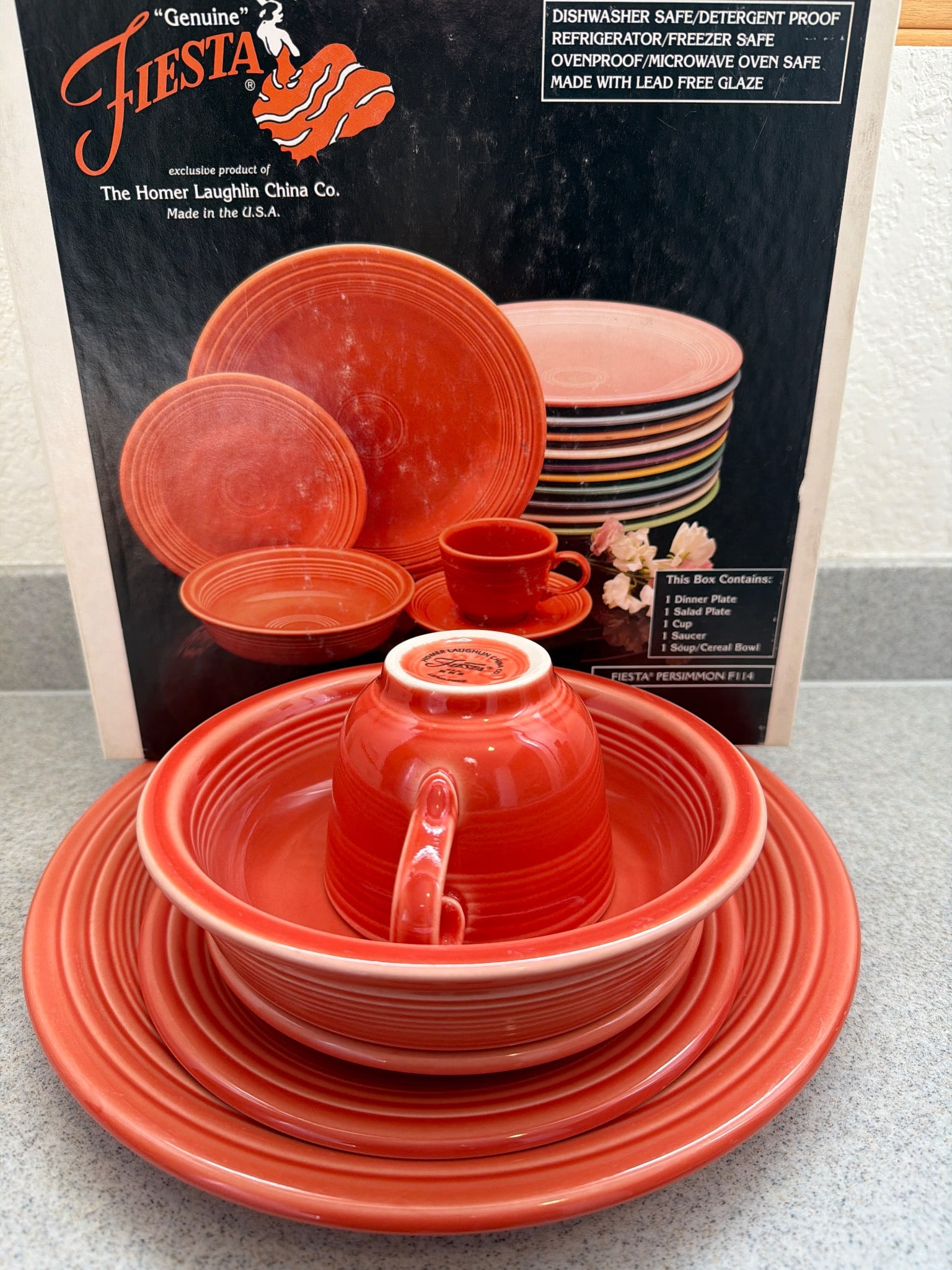 Homer Laughlin Fiesta Persimmon 5-Piece Dinnerware Set: Homer Laughlin Fiesta 5-piece dinnerware set in the Persimmon glaze, made in the USA. The set includes 1 dinner plate, 1 salad plate, 1 cup, 1 saucer, and 1 soup/cereal bowl. The dishware features a l