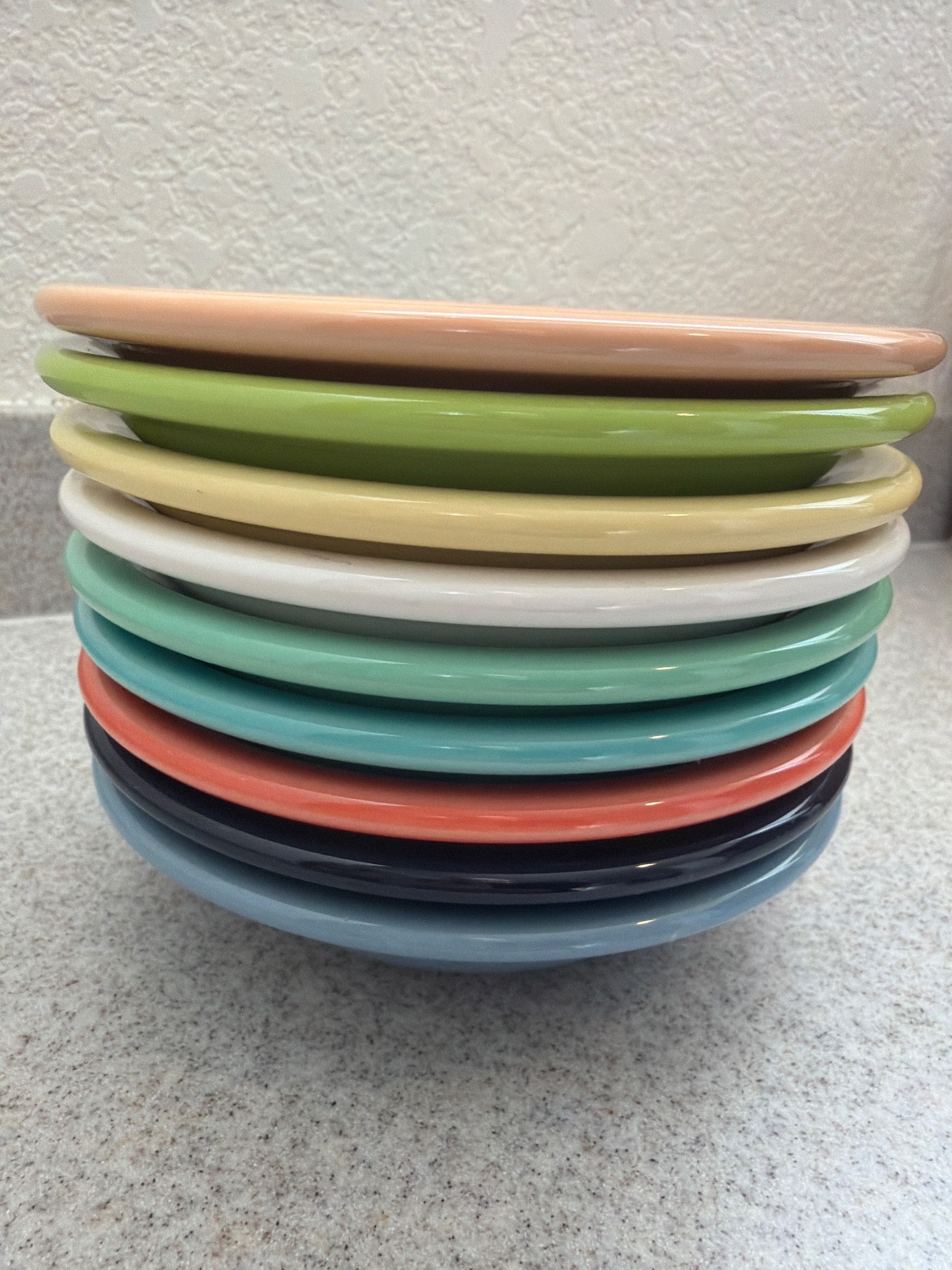 Fiesta Salad Plates in Multicolored Glaze: Vintage Fiesta salad plates featuring a vibrant multicolored glaze. Produced by the Fiesta line, these plates are crafted from durable ceramic and showcase the signature concentric ring design. The se
