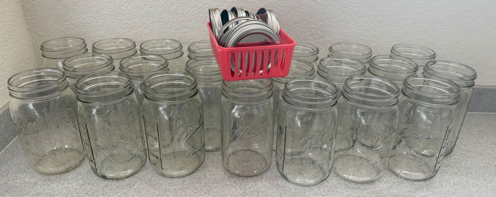 Clear Glass Jars with Lids: Clear glass jars, featuring 17 jars and a set of metal lids stored in a plastic basket. The jars are standard-sized, suitable for storage or preservation purposes. All items are in good condition, sho