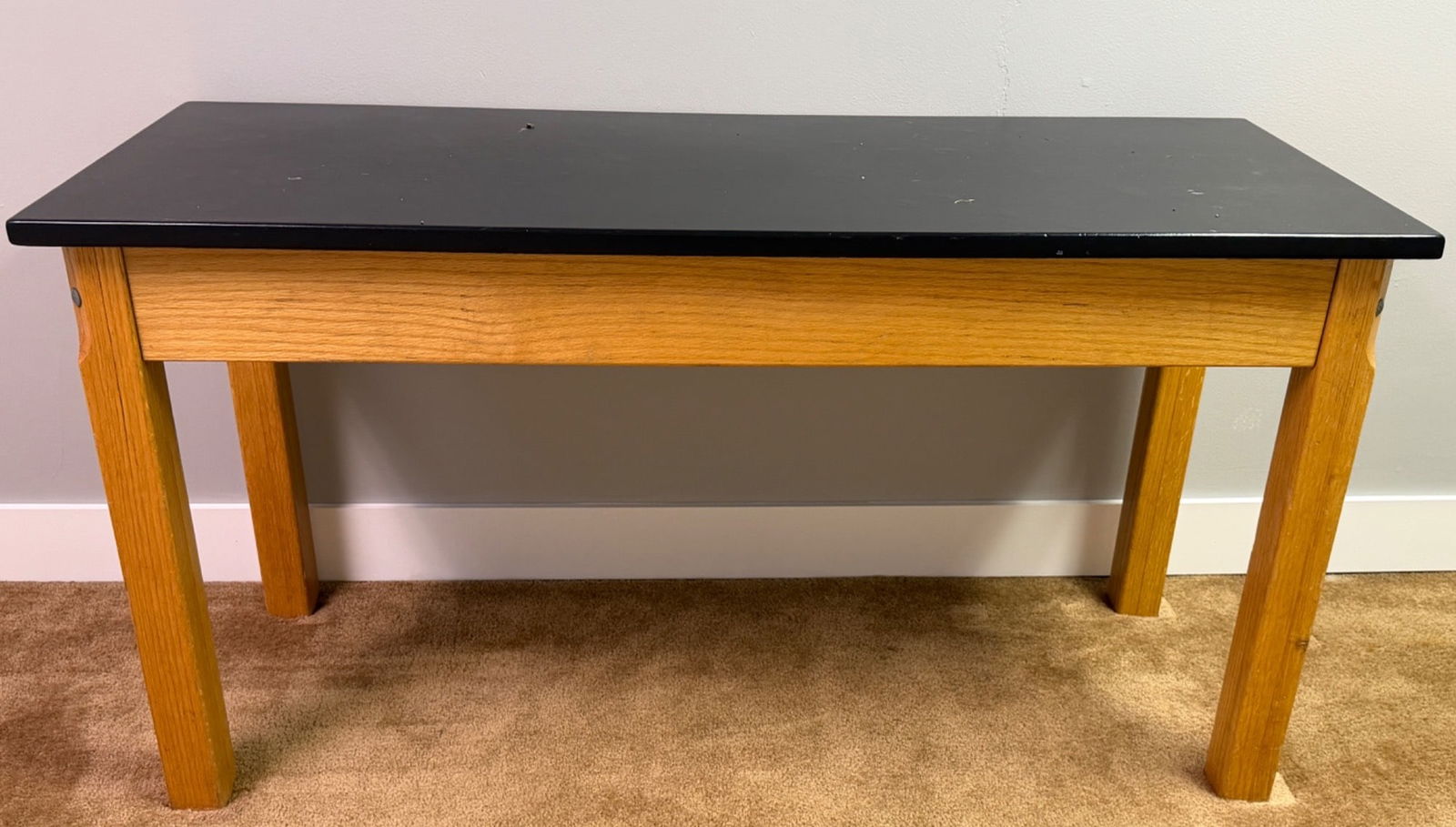 Science Table With Refinished Top and Oak Frame: Science table featuring a refinished black top with an oak frame and sturdy construction. The top has a smooth surface, showing a few marks consistent with use. Suitable for use in various settings in