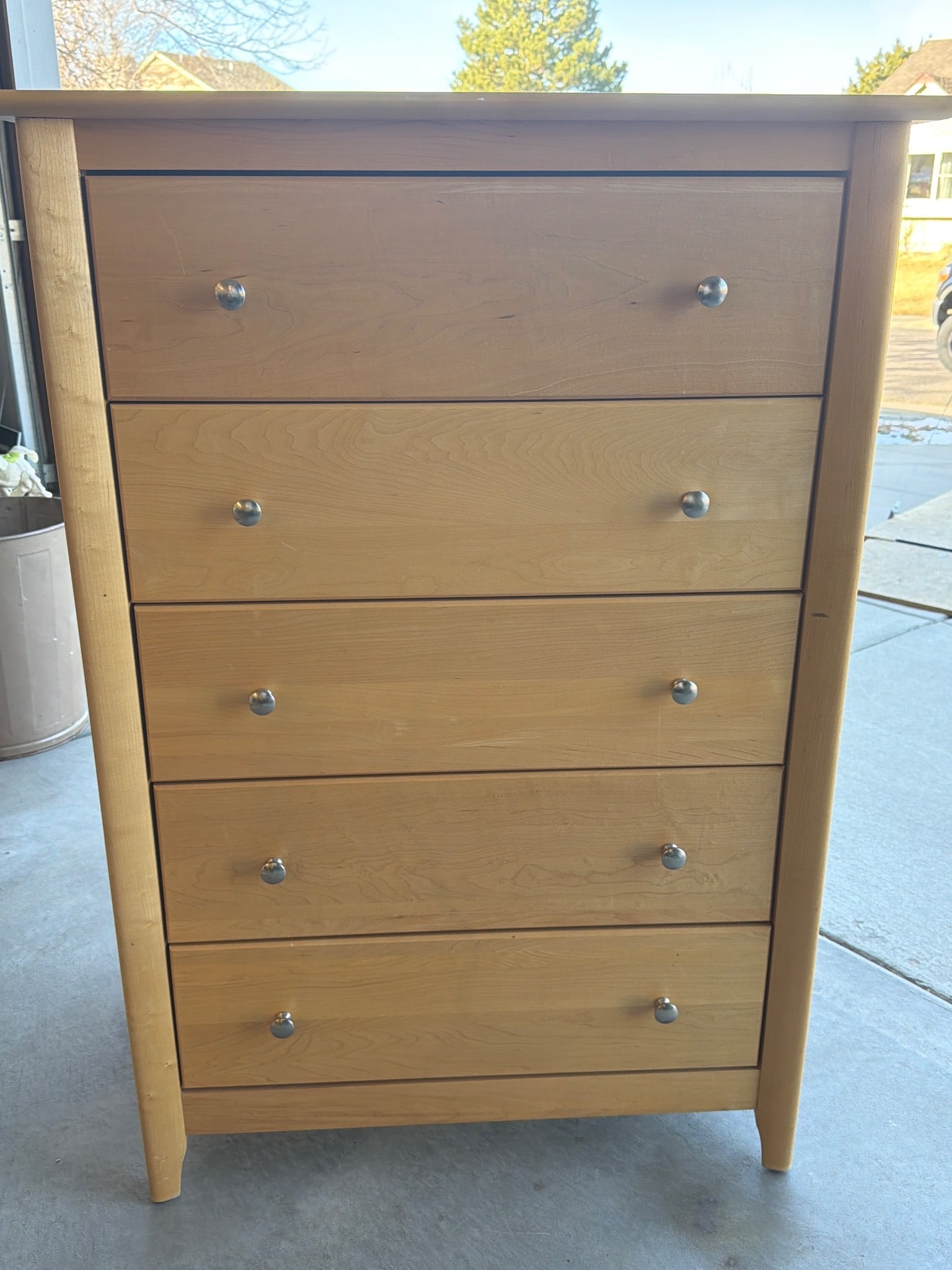 Five-Drawer Wood Chest of Drawers Made in Canada: Five-drawer chest of drawers crafted in Canada, featuring a natural wood finish. The piece includes knob-style metallic handles and dovetail drawer construction. The back panel has manufacturing stamp