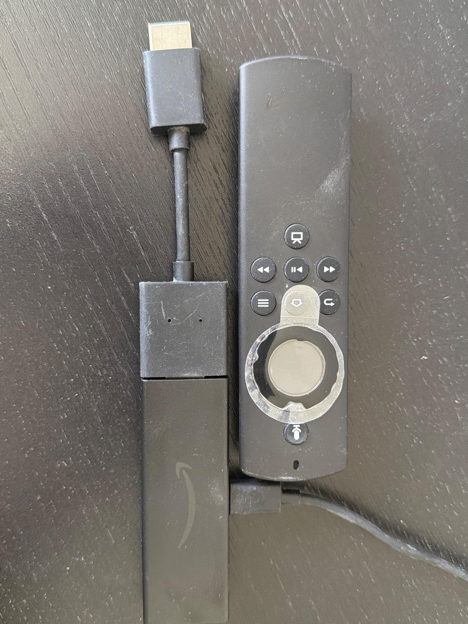 Amazon Fire TV Stick with Alexa Voice Remote: Amazon Fire TV Stick with Alexa Voice Remote included for streaming access. This device connects to an HDMI port and is suitable for various streaming applications. Some signs of wear are evident on b