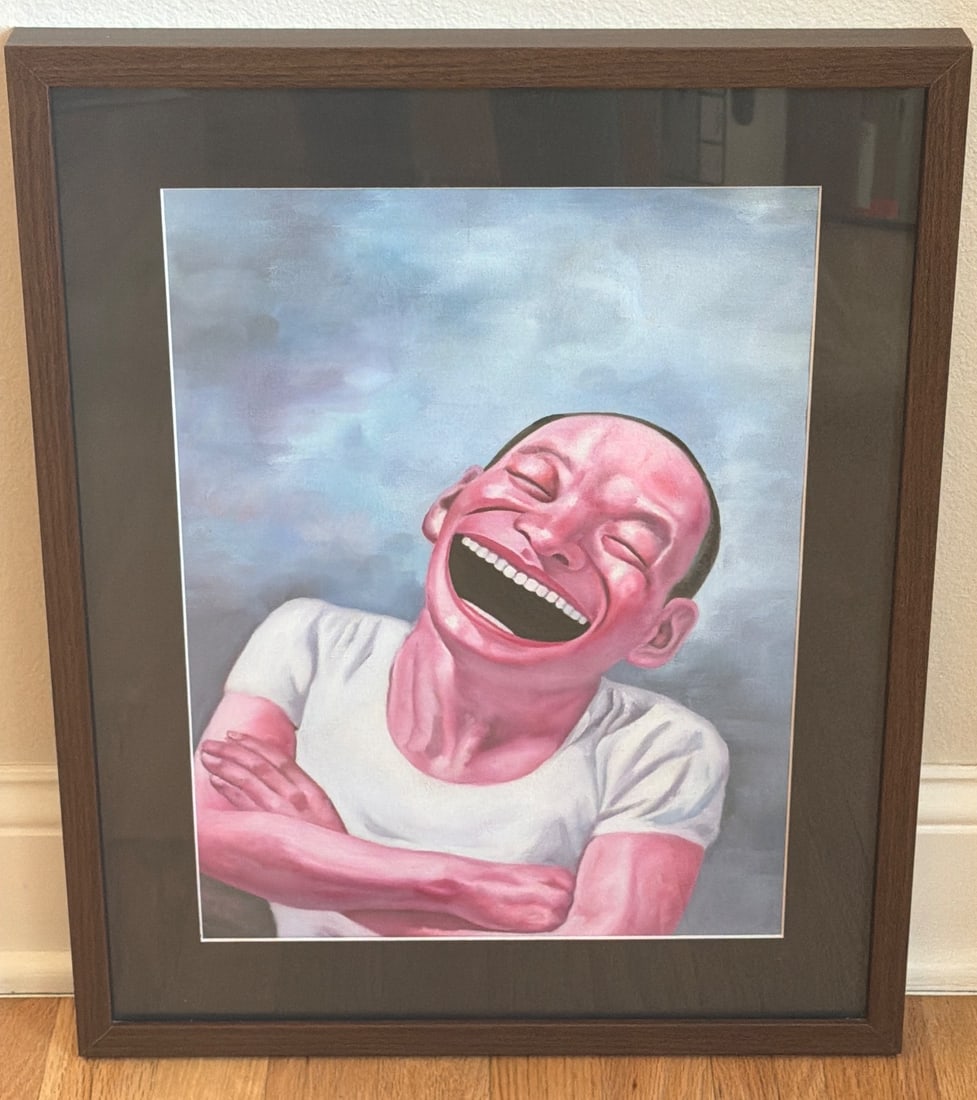 Framed Wall Art of Smiling Figure in Ikea Ribba Frame: Framed wall art depicting a pink-skinned figure laughing, mounted within an IKEA Ribba frame. The frame is dark brown and the backing shows a label with product details. The artwork includes vibrant c