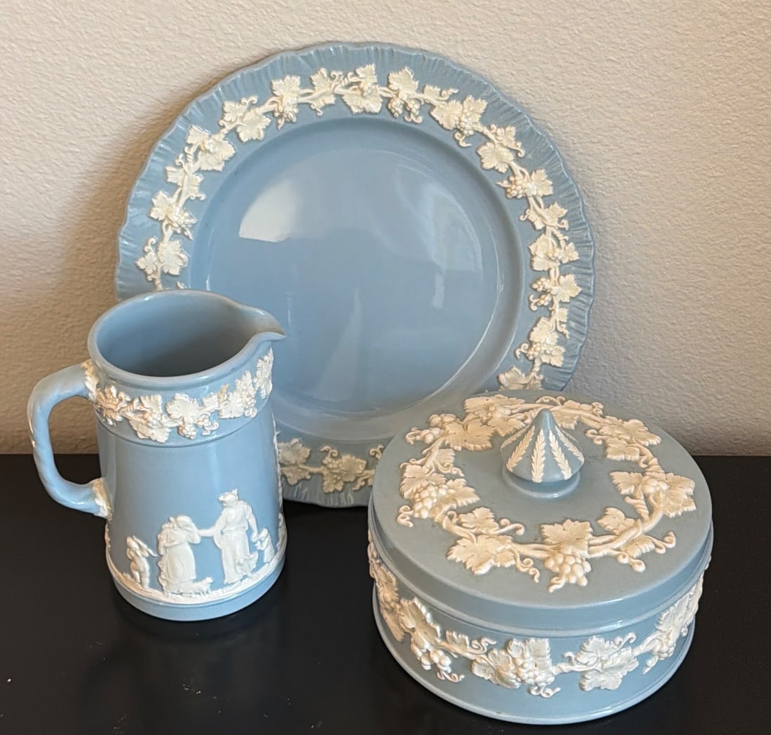 Vintage Wedgwood Blue Jasperware Set with Plate, Lidded Bowl, and Pitcher: A vintage Wedgwood blue Jasperware set including a decorative plate, lidded bowl, and pitcher. Each piece features the signature matte blue finish with applied white relief in classical motifs. The ba