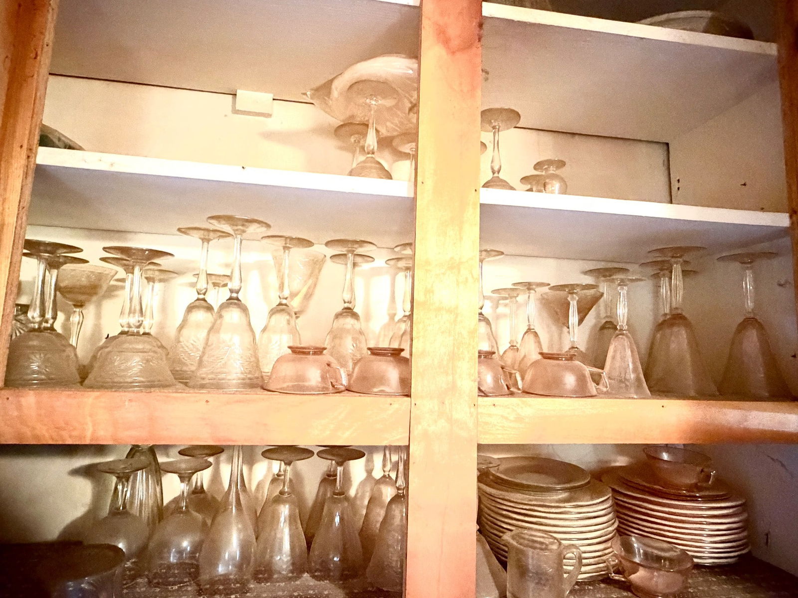 Vintage Glassware and Plates: This collection includes a selection of glassware, plates, and bowls housed within a wooden storage cabinet. The glassware includes stemmed goblets, various patterned tumblers, and other pieces, while