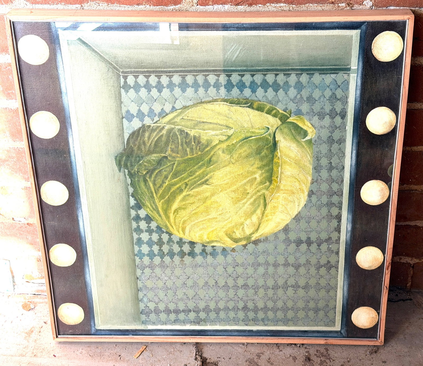 Framed Oil Painting of Cabbage with Decorative Border of Circles: Framed oil painting depicting a cabbage in a box-like setting with a patterned base, surrounded by a decorative border featuring a series of circular motifs. The painting is stretched on a canvas and 