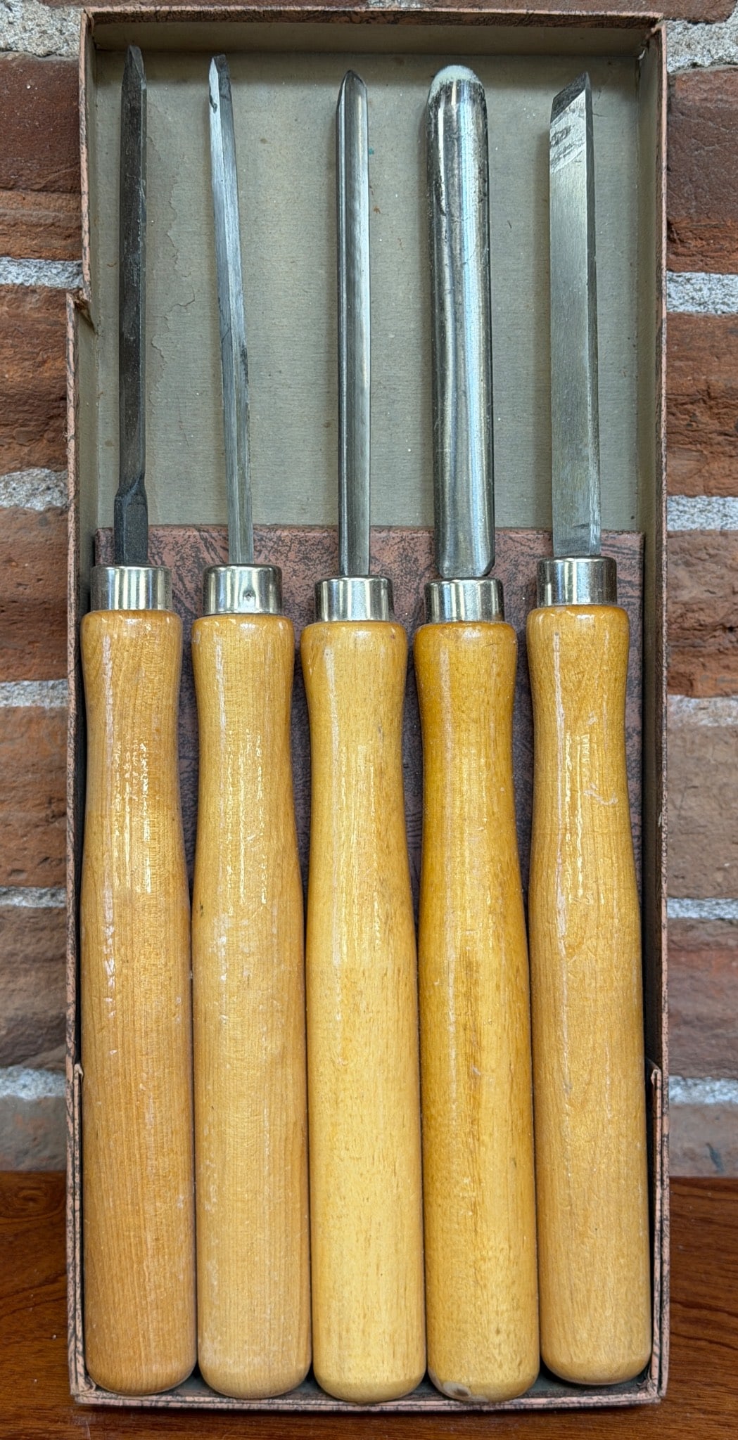 Five Woodworking Chisels with Wooden Handles: Five woodworking chisels featuring wooden handles and steel blades. Includes a variety of chisel types suitable for carving and woodworking. Chisels measure approximately 11 inches in length including