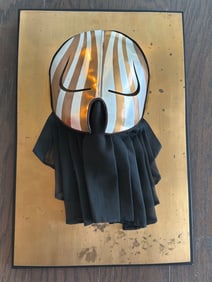 Metal and Fabric Wall Art Featuring Stylized Mask Design