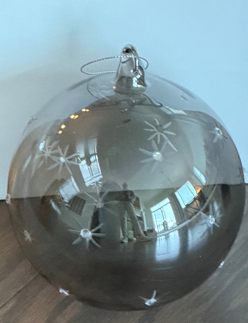 Silver-Tone Glass Ornament with Etched Star Pattern in Box: Glass ornament featuring a reflective silver-tone finish with etched star patterns. Includes original box with protective tissue paper. Dimensions: approximately 5 inches in diameter, as measured with