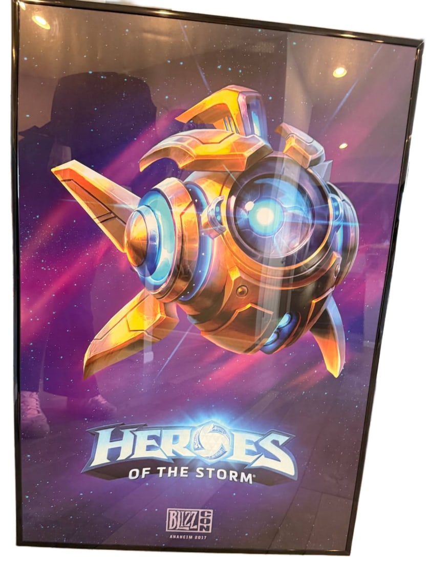 Framed ‘Heroes of the Storm’ Poster by Blizzard Entertainment: Framed poster featuring promotional artwork for Blizzard Entertainment's 'Heroes of the Storm.' The design showcases a robotic-themed character against a vibrant purple space-like background. Marked w