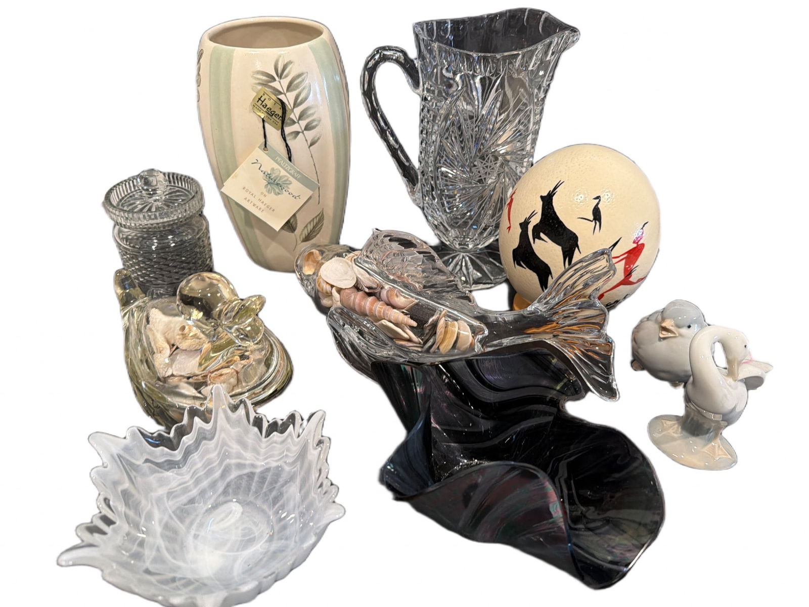 Decorative Glass and Ceramic Pieces Including Haeger Vase: Decorative homeware, including a signed Royal Haeger vase with botanical design, a cut glass pitcher, a glass candy dish with lid, a glass sculpture with shells, an etched glass bowl, a black glass ab