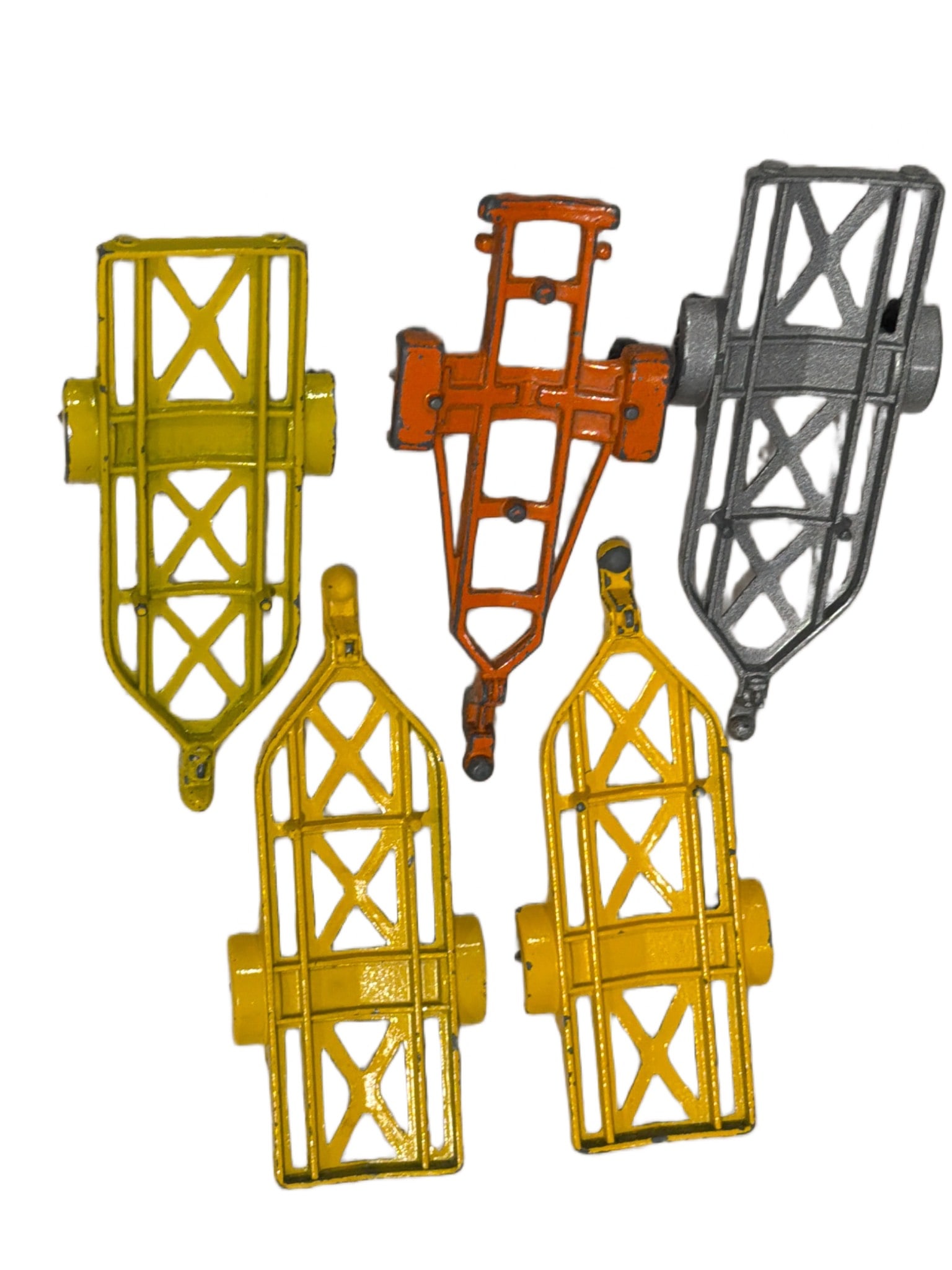 5 Yonezawa Japan Die-Cast Toy Trailer Frames: 5 vintage die-cast toy trailer frames made by Yonezawa, marked ‘Yonezawa Toys’ and ‘Japan.’ The set includes three yellow, one orange, and one gray trailer frame, each designed with detailed c