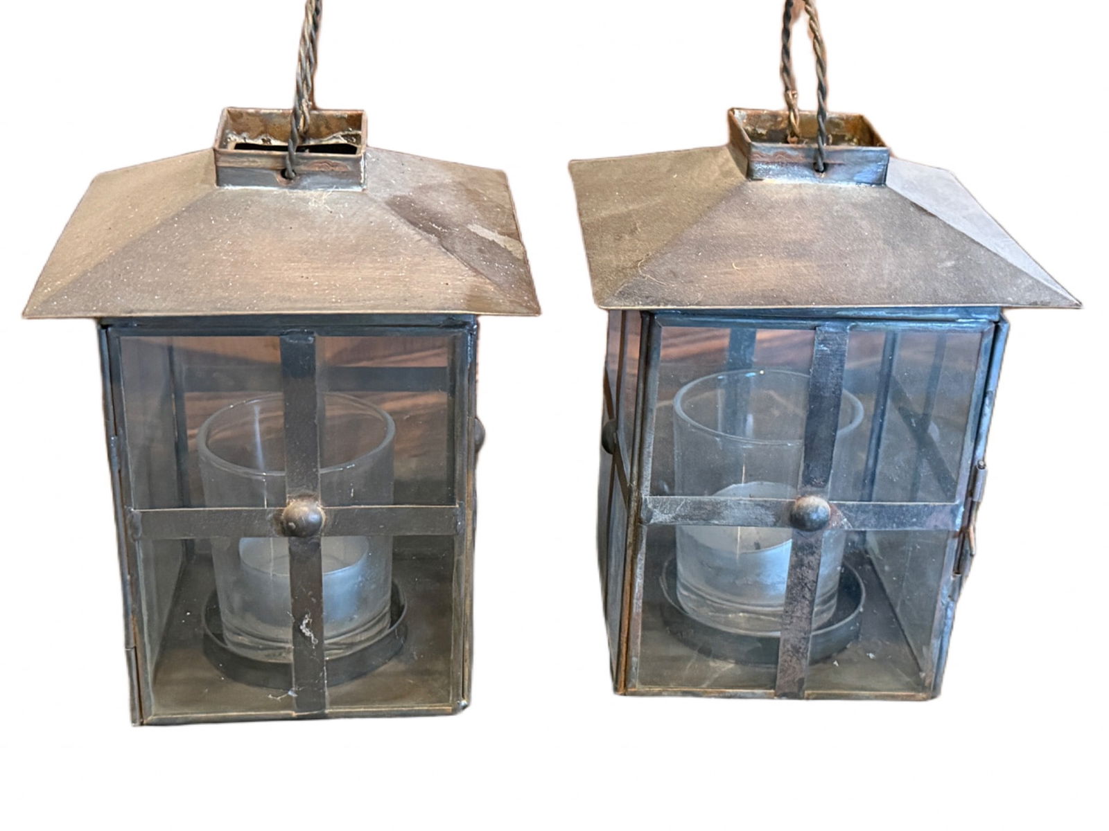Metal and Glass Lantern Candle Holders: Metal and glass lantern-style candle holders with interior compartments designed to hold votive candles or tea lights. Each lantern features a hinged door with latch for easy access and a metal handle