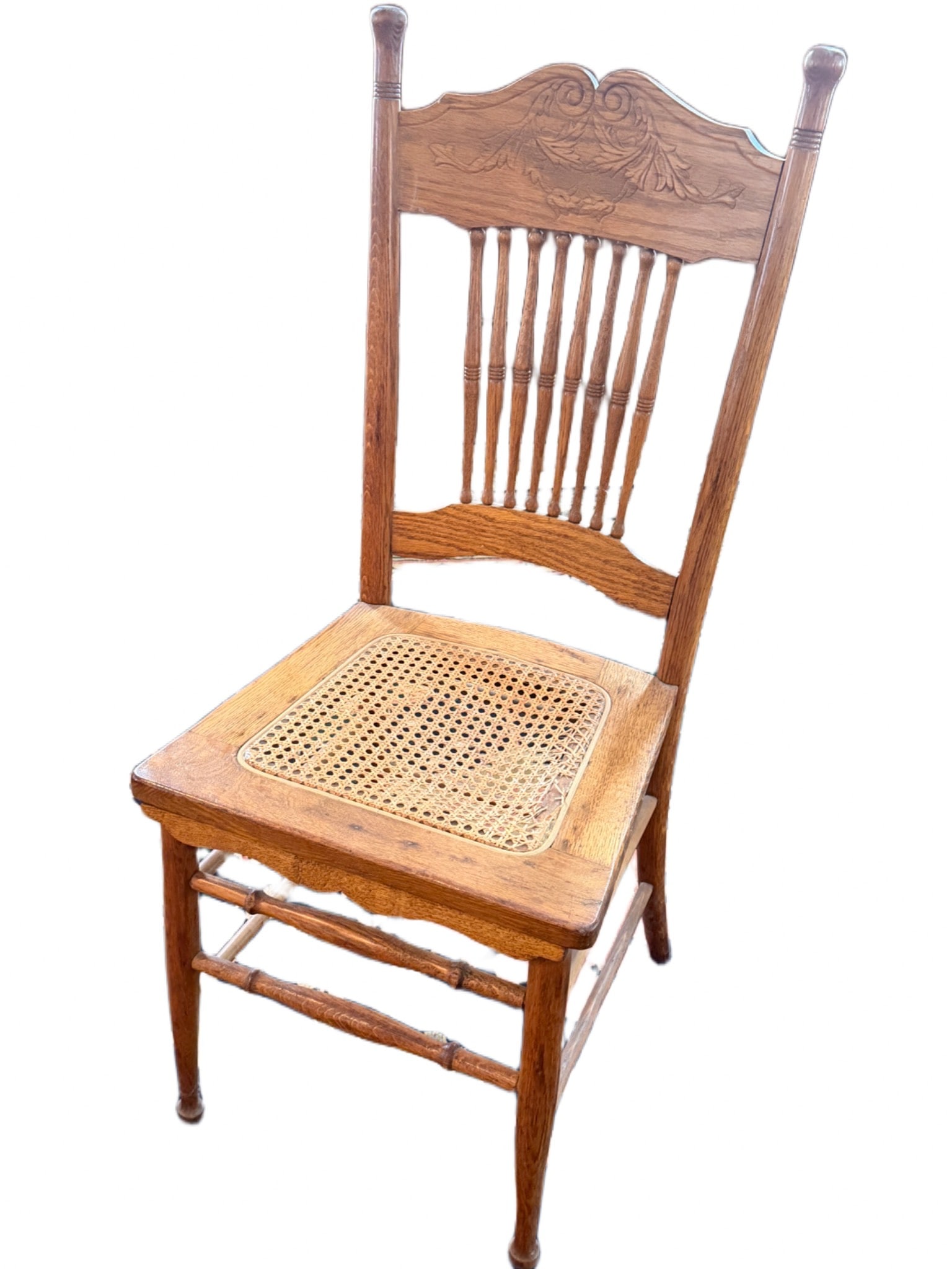 Wood Dining Chair with Cane Seat and Decorative Back Design: Wooden dining chair featuring a cane-woven seat and decorative carved detailing on the backrest. The chair has turned wooden legs and a sturdy structure. The total height is 39 inches, the seat height