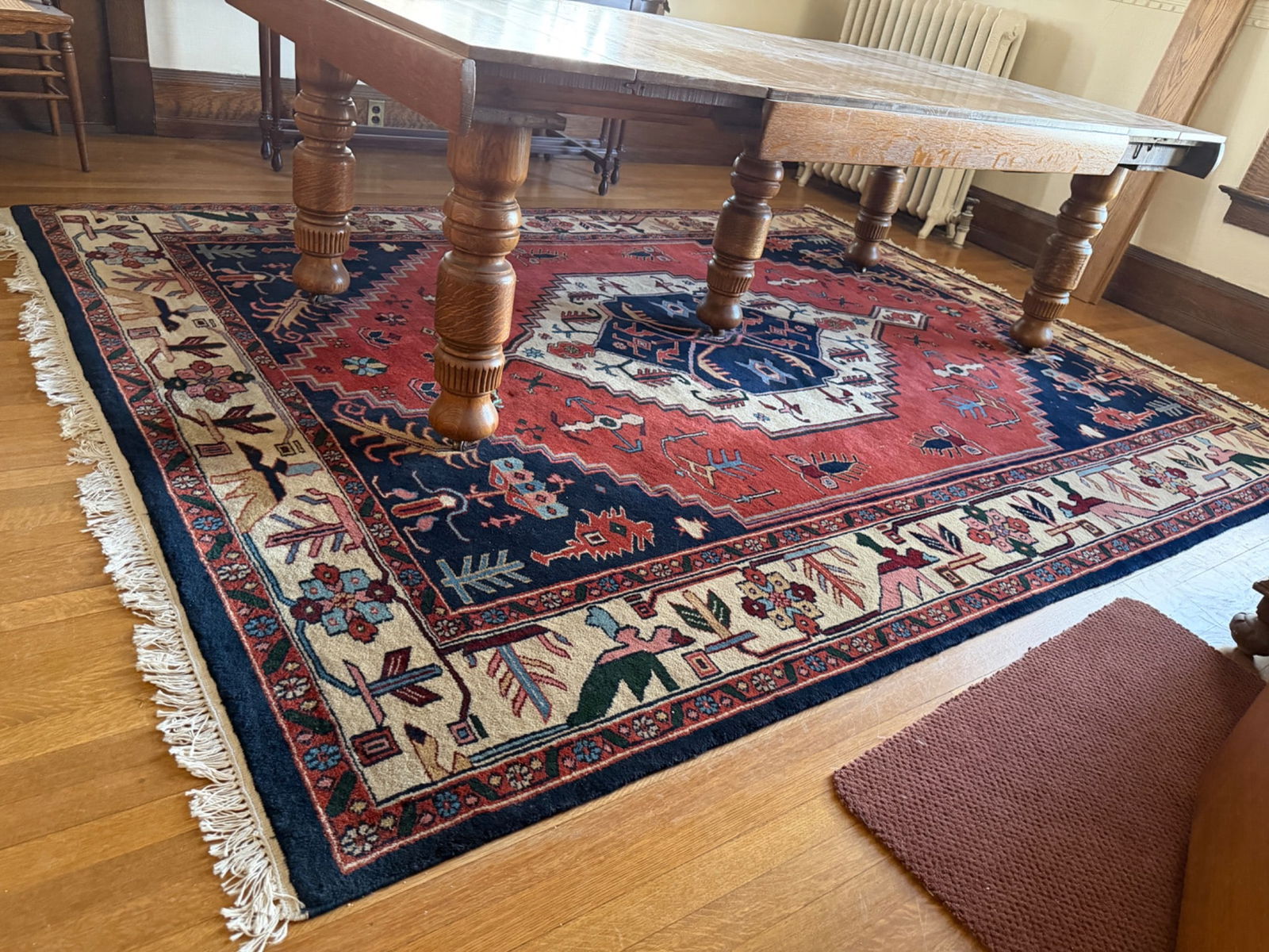Hand-Knotted Oriental Area Rug by Michaelian & Kohlberg: Hand-knotted wool area rug crafted by Michaelian & Kohlberg, featuring a bold red, navy, and cream palette with intricate geometric and floral motifs. Originating from India, this rug showcases a deta