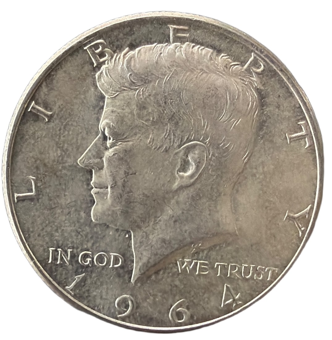 1964 Kennedy Half Dollar, 90 Percent Silver, 13 Grams: A 1964 Kennedy Half Dollar composed of 90 percent silver, with a weight of approximately 13 grams. Featuring the profile of President John F. Kennedy on the obverse and the Presidential Seal on the re