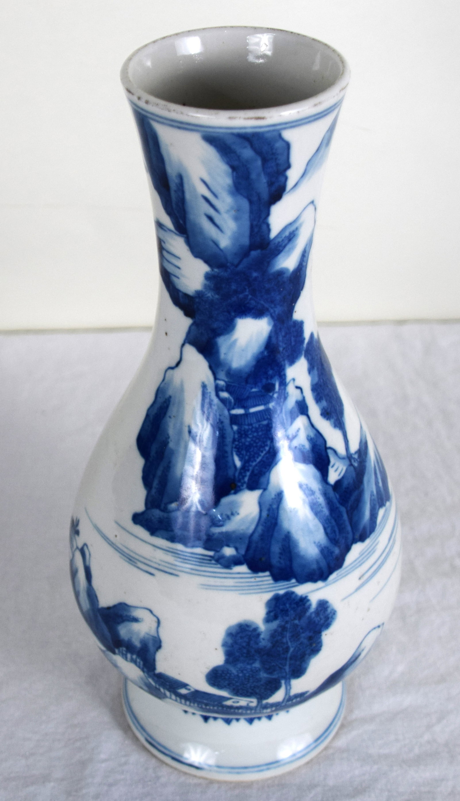 Chinese Vase: Chinese ceramic blue and white vase with trees and mountains and man in boat design. Marked. Dimensions: 13" Height