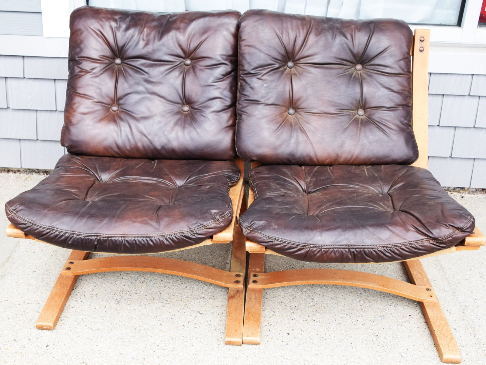 Pair of Loungers: Pair of mid century lounge chairs, 1950s/60s with button leather tufted cushions on shaped wooded base. Dimensions: 30" Height, 15" Seat Height, 24" Width x 25" Depth