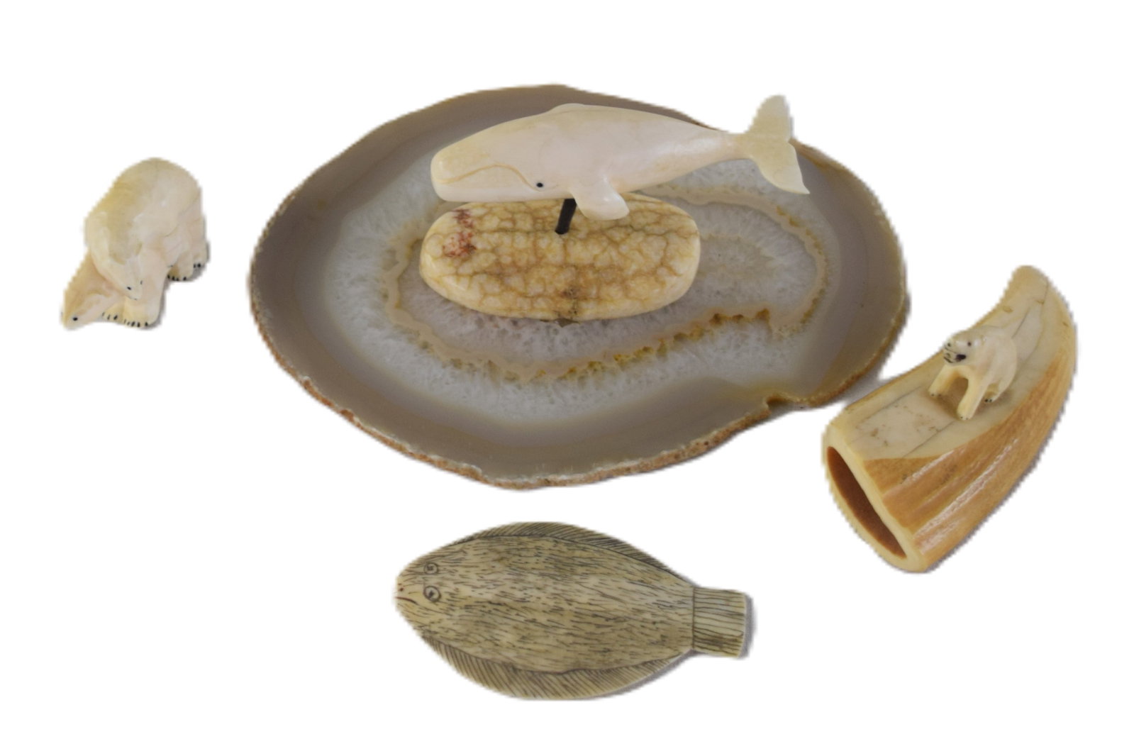 Carved Whalebone Lot: Four carved figures to include a polar bear on a tooth, a whale mounted on bone, a flounder and a polar bear accompanied by a stone platform. Dimensions: Range from 2.5" to 4" L