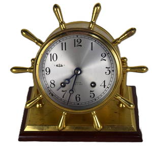 Chelsea Ship's Bell Clock: Brass Chelsea ship's bell clock with mark on dial, with ship's wheel design on a brass and wooden base. Limited edition #238. With a presentation "To David J. Sargeant, Dean and President, From his fr