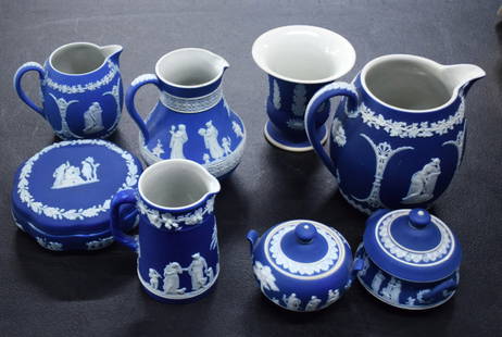 8 Piece  Wedgewood Lot: Eight piece of blue and white jasperware Wedgewood to include 4 pitchers with handles (4", 5.5", 5", 6"), two covered sugars with lids (4" H) and round circular covered box (5" Dia.) and a vase, all m