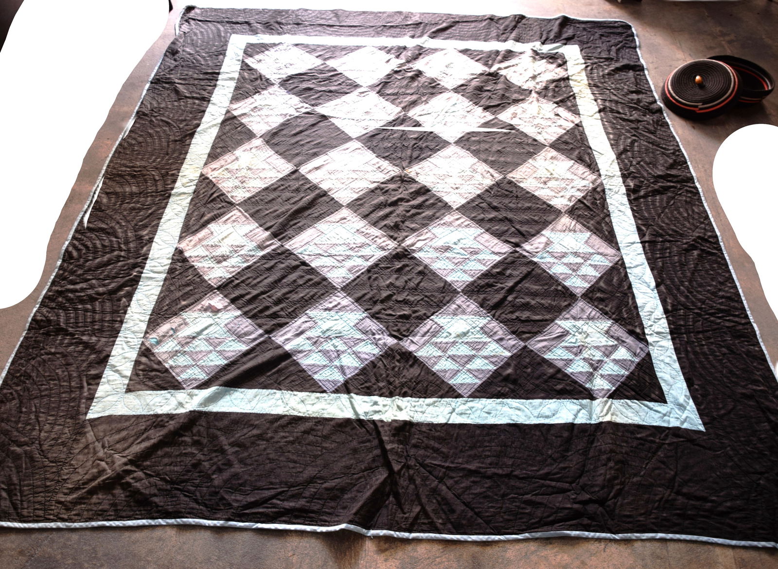 Amish Quilt: Fine Amish quilt with multiple design diamonds-black, white, gray colors along with an Amish basket with lid used to design the colors of quilts. Dimensions: 6'4" x 7'7"
